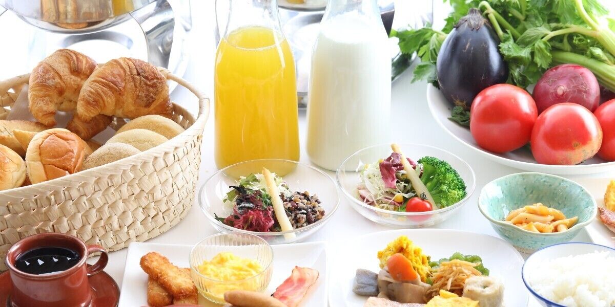 A breakfast buffet with croissants, eggs, and various salads.