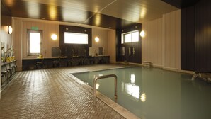 A swimming pool area with a tiled floor, a pool with a metal safety rail, and a bench. - Shigakogen Hotel Ichibokaku (Yamanouchi)