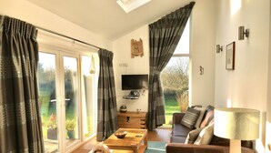 A modern living room with a sofa, coffee table, and a dog. - Kokopelli cottage near the Donkey sanctuary Sidmouth , modern and pet friendly. (Sidmouth)