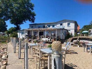 Ein Strandgrundstück mit einem großen Gebäude, Außenbereich und Sandfläche.