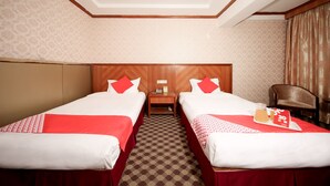 A hotel room with two beds, a wooden headboard, a small table with a phone and a lamp, and a chair. - OYO 8027 Li Hu Business Hotel (Shenzhen)