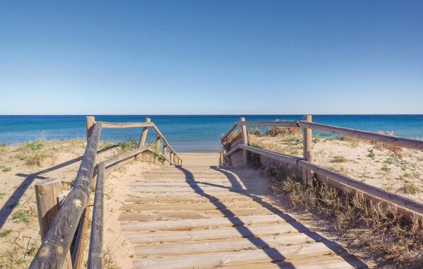 Walk along the weathered boardwalk to the beach.