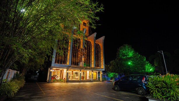 A hotel with a modern design, featuring a well-lit entrance and a parking area. - White Gate Residency (Vaikom)