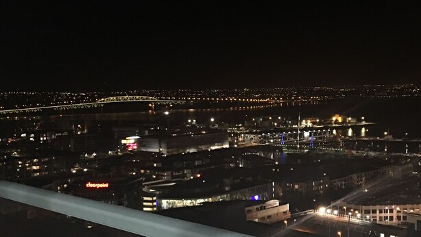 A nighttime cityscape with illuminated buildings and a bridge. - Altitude (Auckland)