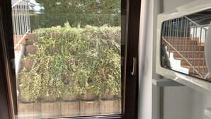 Eine Tür mit Blick auf einen Garten und eine Treppe.