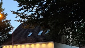 A building with a sloped roof, a single entrance with a door, and a small window on the side. - Apartment-32609de (Hüllhorst)