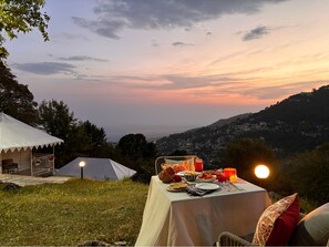 Tavolo da pranzo all'aperto con vista sulla città al tramonto.