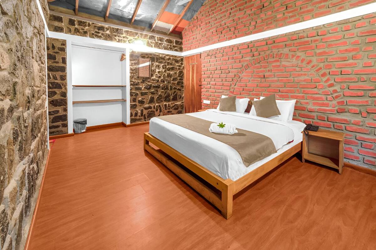 Ein Schlafzimmer mit einem hölzernen Bett, einer Ziegelwand und einer Steinwand.