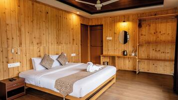 Una camera da letto con rivestimenti in legno, un letto, comodini, uno specchio e una ventola a soffitto.