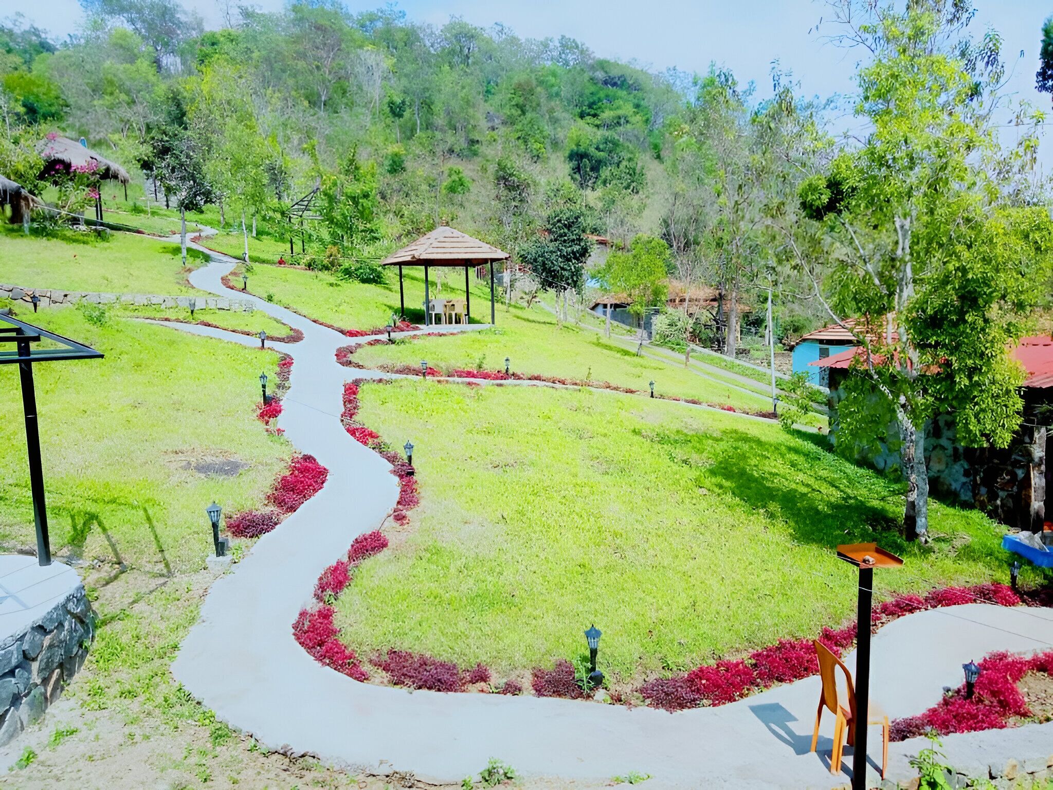 A park with winding pathways, a gazebo, and a stone wall.