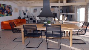Une cuisine moderne avec un grand îlot central, des chaises noires et une table en bois.
