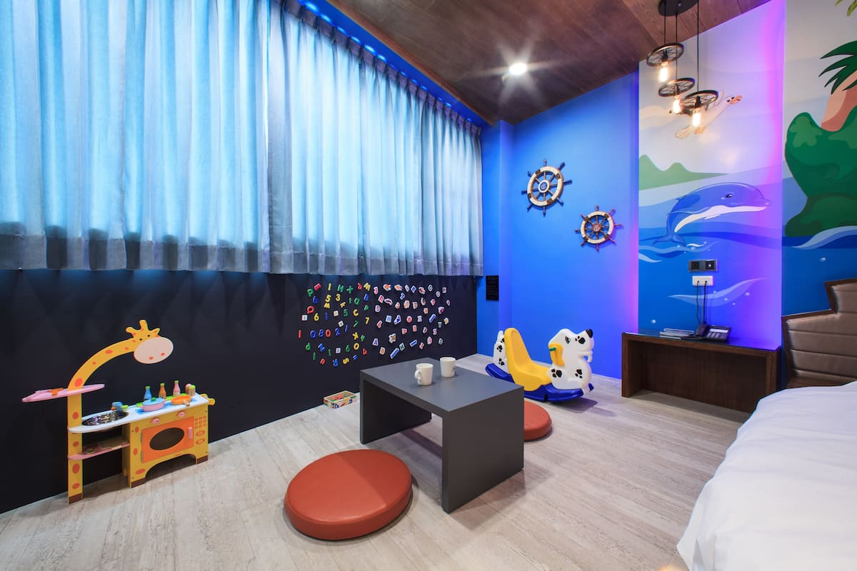 Habitación ideal para niños, con espacio de juegos, cama y un mural en la pared.