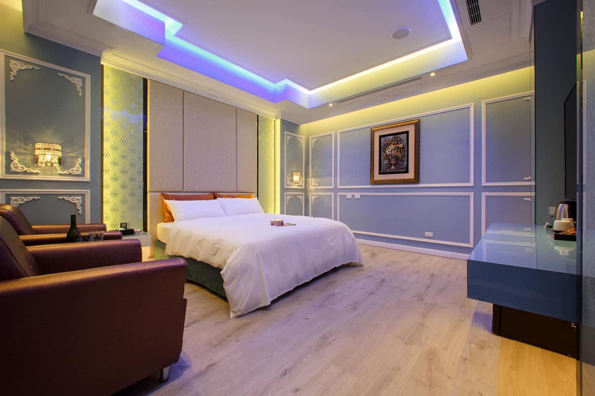 Un dormitorio moderno con cama, sofá y vitrina de cristal.