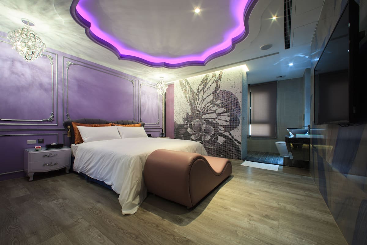 Un dormitorio moderno con una cama grande, una mesita de noche y una obra de arte colgada en la pared.