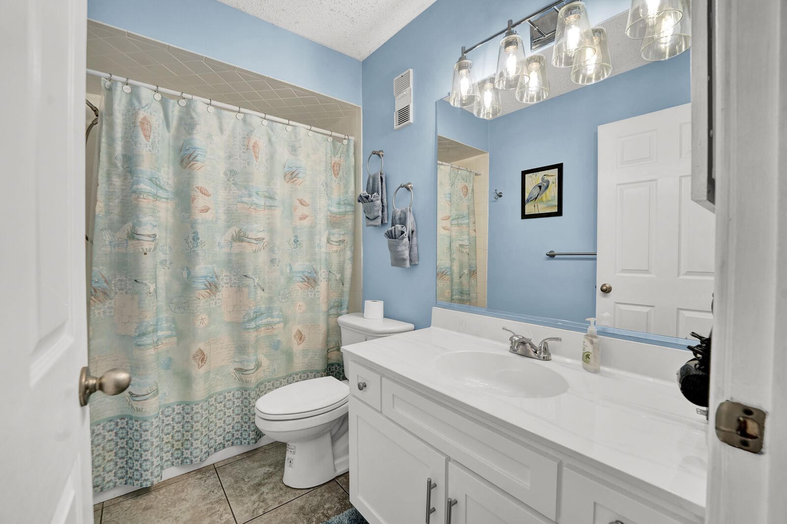 Une salle de bain équipée de toilettes, d’un lavabo et d’un rideau de douche.