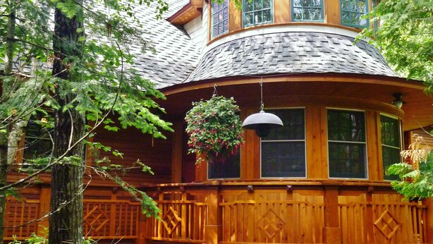 A wooden cabin with a turret, large windows, and a hanging flower basket. - The Trail's Edge / "Captain's Quarters" Is A Gorgeous Retreat, In Any Season.  (Duluth)