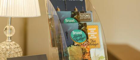 A display stand with travel brochures for Brunei, including a 'Brunei Tourism Map' and 'Brunei Diving Packages'. A 'CONCIERGE' sign is also visible.