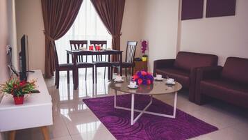 A modern living room with a dining area, a sofa, and a coffee table with flowers.