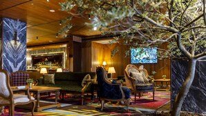 A lobby with a bar area, seating arrangements, and a large screen. - Inhouse Hotel Grand (Taichung)