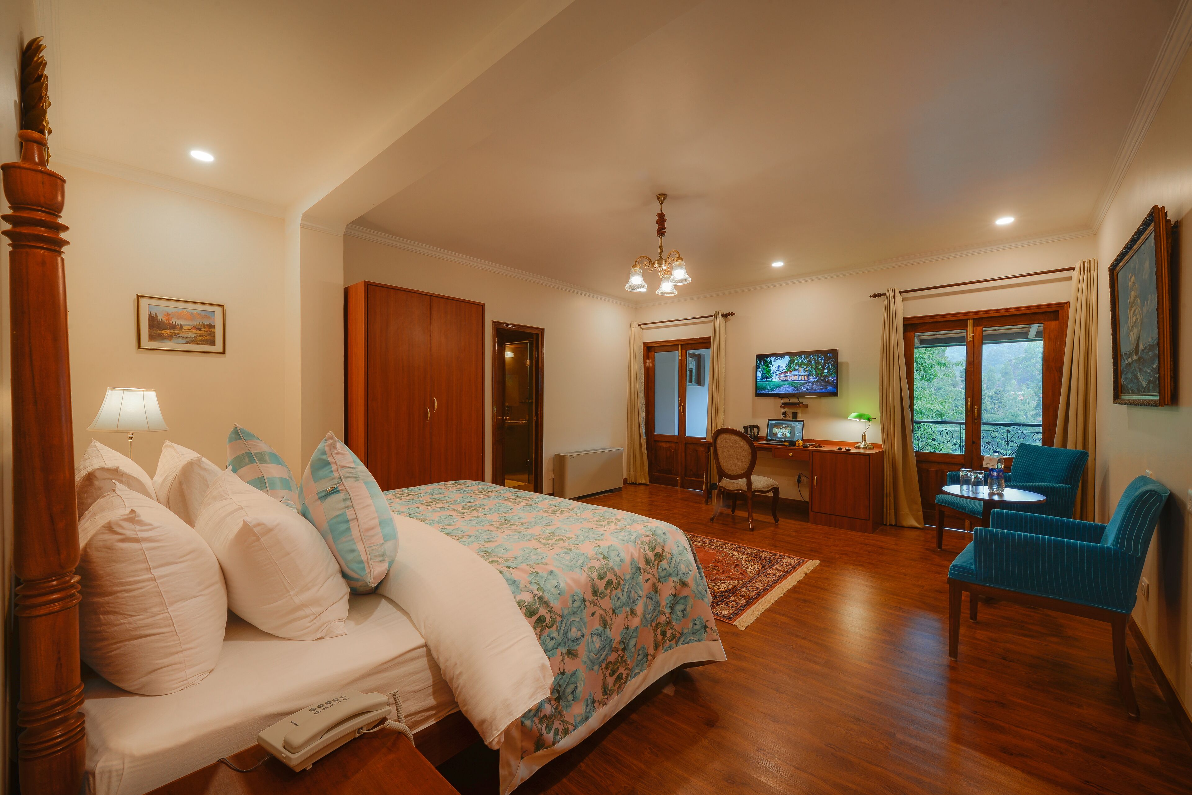 Un dormitorio con cama, escritorio, silla y televisor.