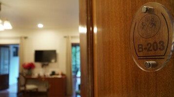 Una puerta de madera con un panel de vidrio que muestra el número "B-203".