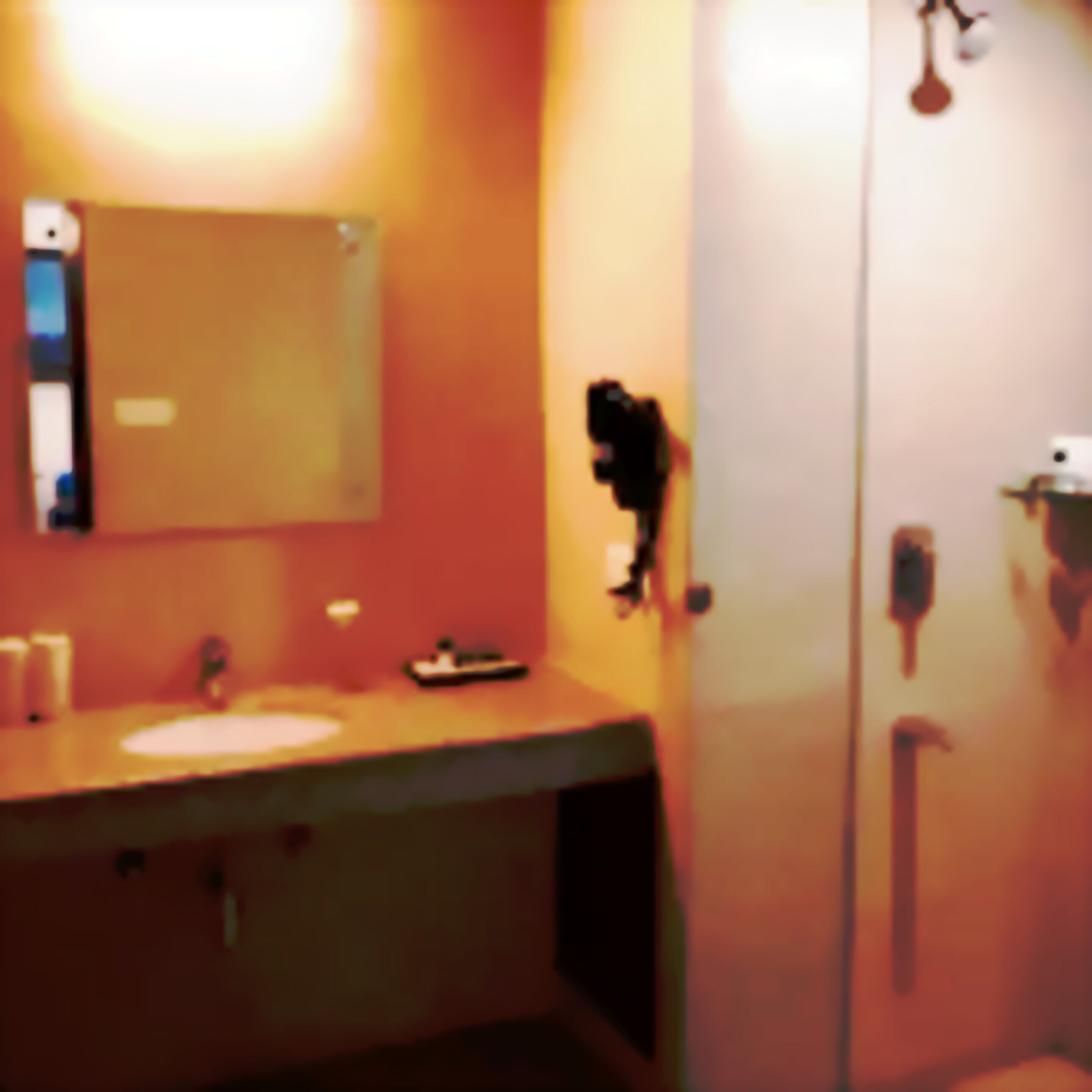 Un baño con lavamanos, espejo y puerta de ducha de vidrio.