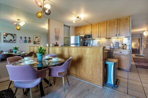 Eine moderne Küche mit Holzausstattung, Edelstahlgeräten und einer zentralen Kochinsel mit Sitzgelegenheiten.