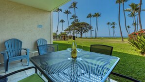 A patio with a table, chairs, and a bottle of wine.