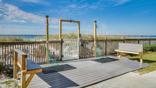 A wooden deck with a bench and a gate, overlooking a beach with a wooden fence and a clear sky. - Beachfront Condo With Sunset Views, 3rd Floor, Pool, Mariner West (Panama City)