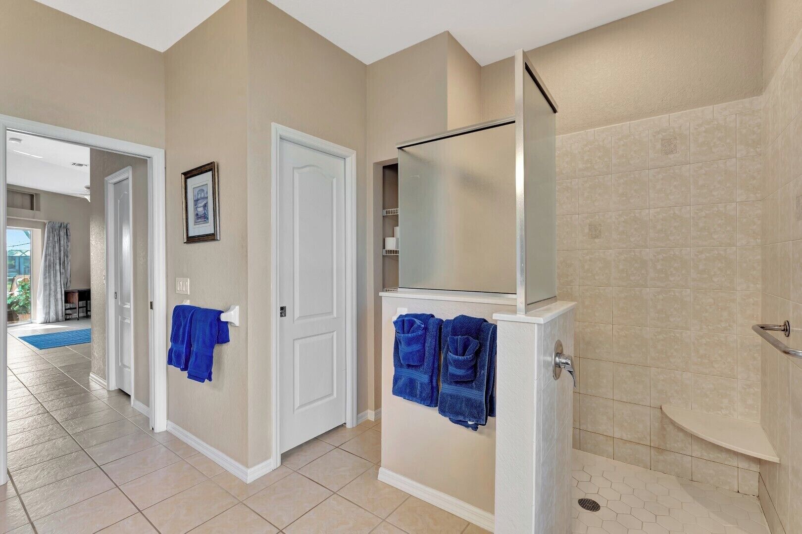 A bathroom with a bathtub, a shower, and a mirror. There are towels hanging on a rack.