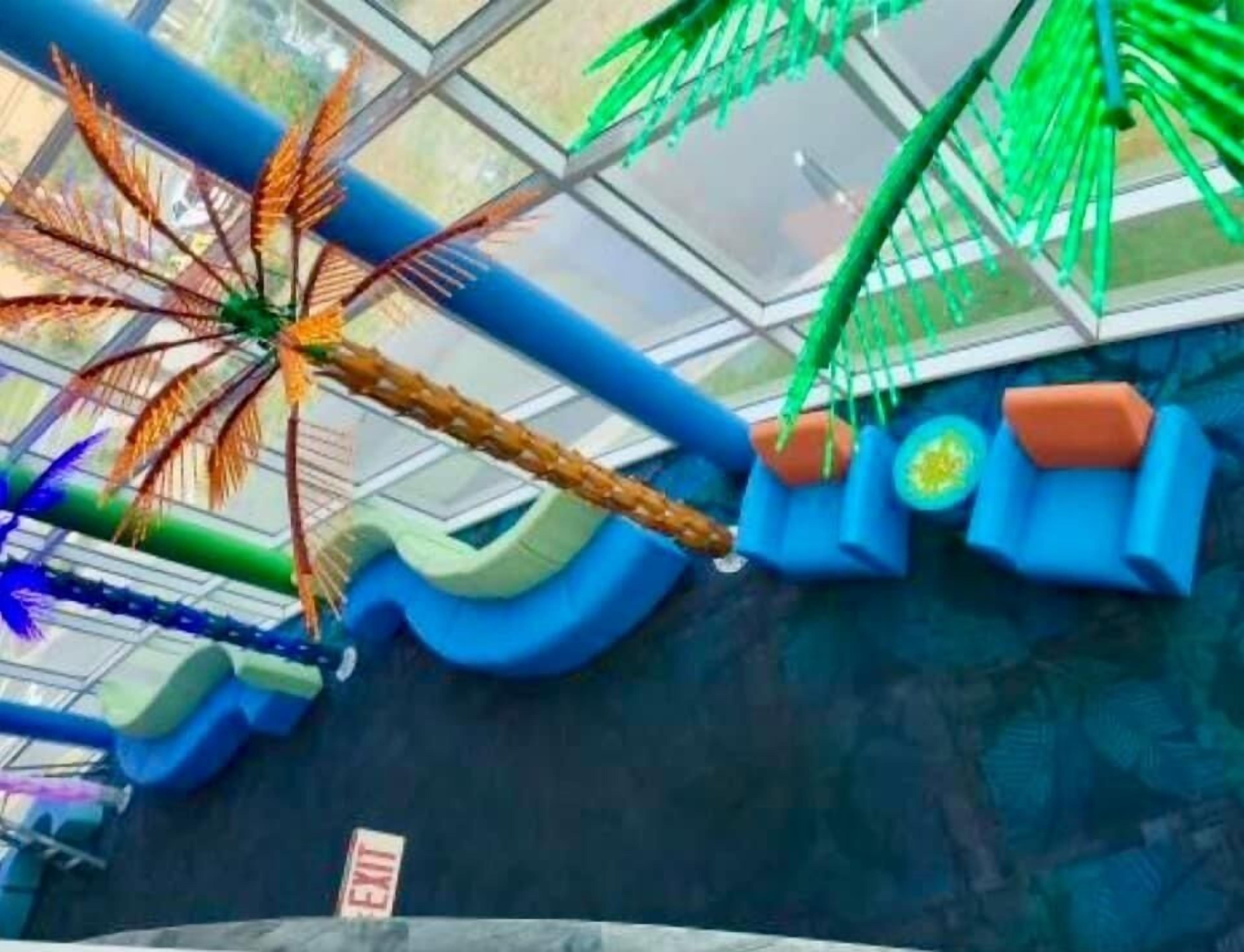 Un'area giochi con uno scivolo, strutture per arrampicata e un piccolo segnale di uscita.