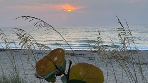 Une plage avec des vagues et un coucher de soleil.