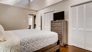 A bedroom with a bed, a dresser, a TV, and a closet. - Katy Trail Cosy and Elegant (Dallas)