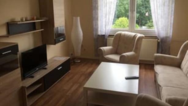 A living room with a sofa, a coffee table, a TV, and a lamp.