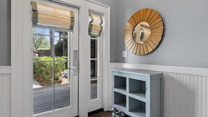 A hallway with a white door, a wooden-framed mirror, and a light blue console table.