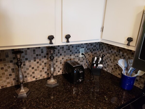 A kitchen with granite countertops, a toaster, a knife block, and decorative vases. - Beautiful Wild Dunes ! Enjoy the Natural Coastal Beauty! (Isle of Palms)