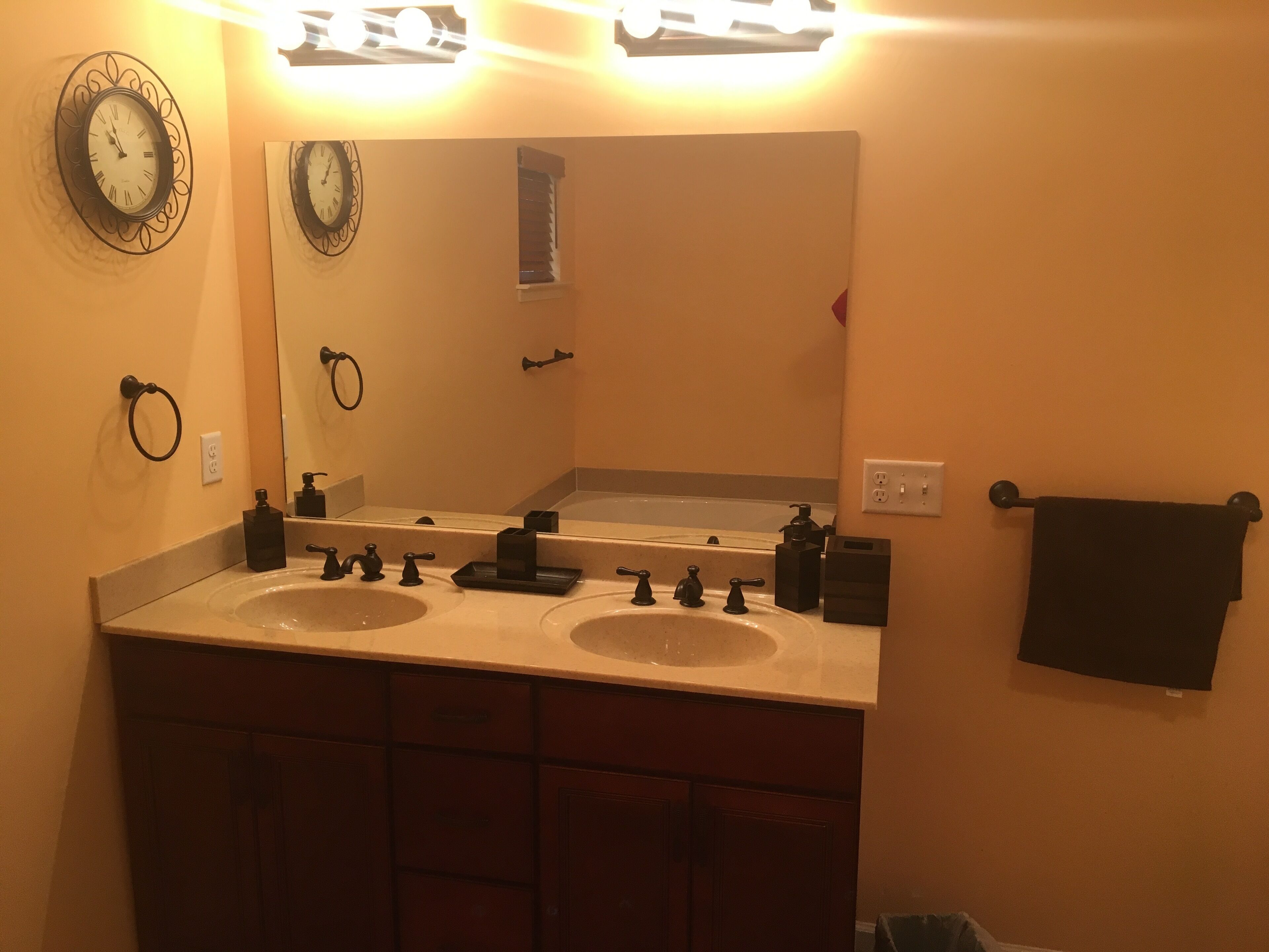 A bathroom with two sinks, a large mirror, and a towel rack.