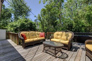 An outdoor deck with wicker furniture, including two sofas and a coffee table.