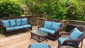 A deck with wicker furniture, including a sofa, chairs, and a table, all with patterned cushions. - Beautiful, Charming, Historic Riverfront and Wrightsville Beach! (Wilmington)