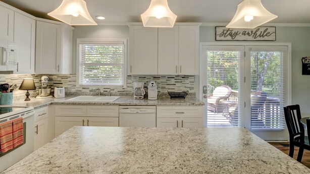 A kitchen with white cabinets, a granite countertop, and pendant lighting. - Beautiful, Charming, Historic Riverfront and Wrightsville Beach! (Wilmington)