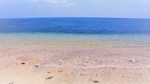 A beach with clear water and a sandy shore. - YOISAMA Sunrise Beach House (Ishigaki)