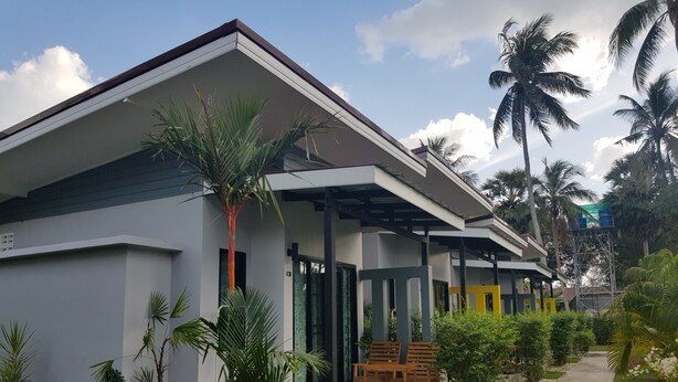 A modern building with a covered outdoor seating area and a pathway leading to it. - Mook Ing Lay (Ko Mook)