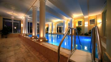 Una piscina techada, sillones reclinables de piscina