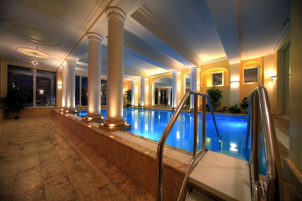 Una piscina techada, sillones reclinables de piscina