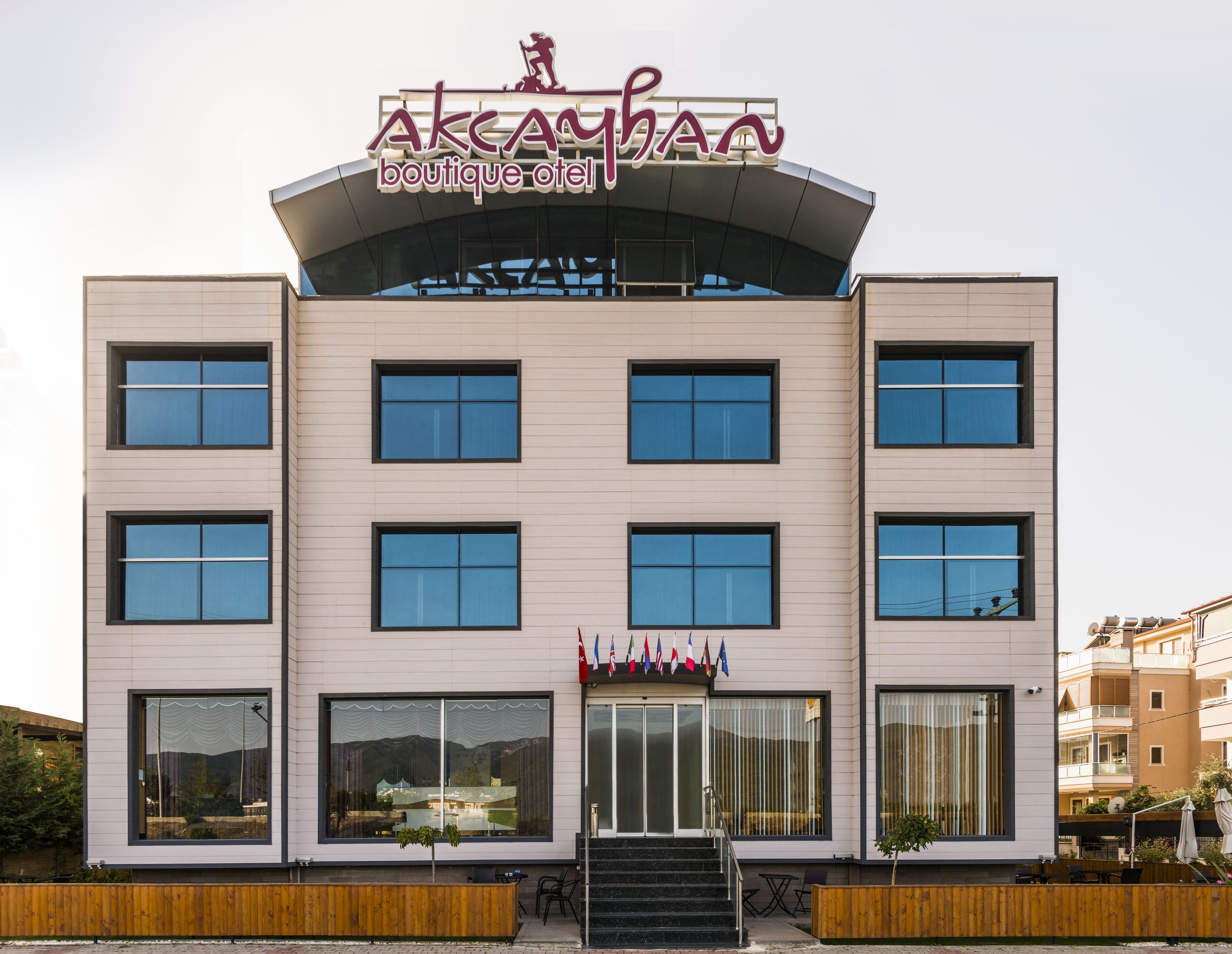 A modern building with a sign reading "AKCAMAN boutique hotel".