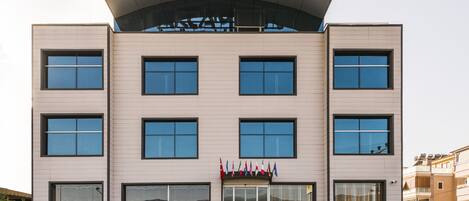 A modern building with a sign reading "AKCAMAN boutique hotel".