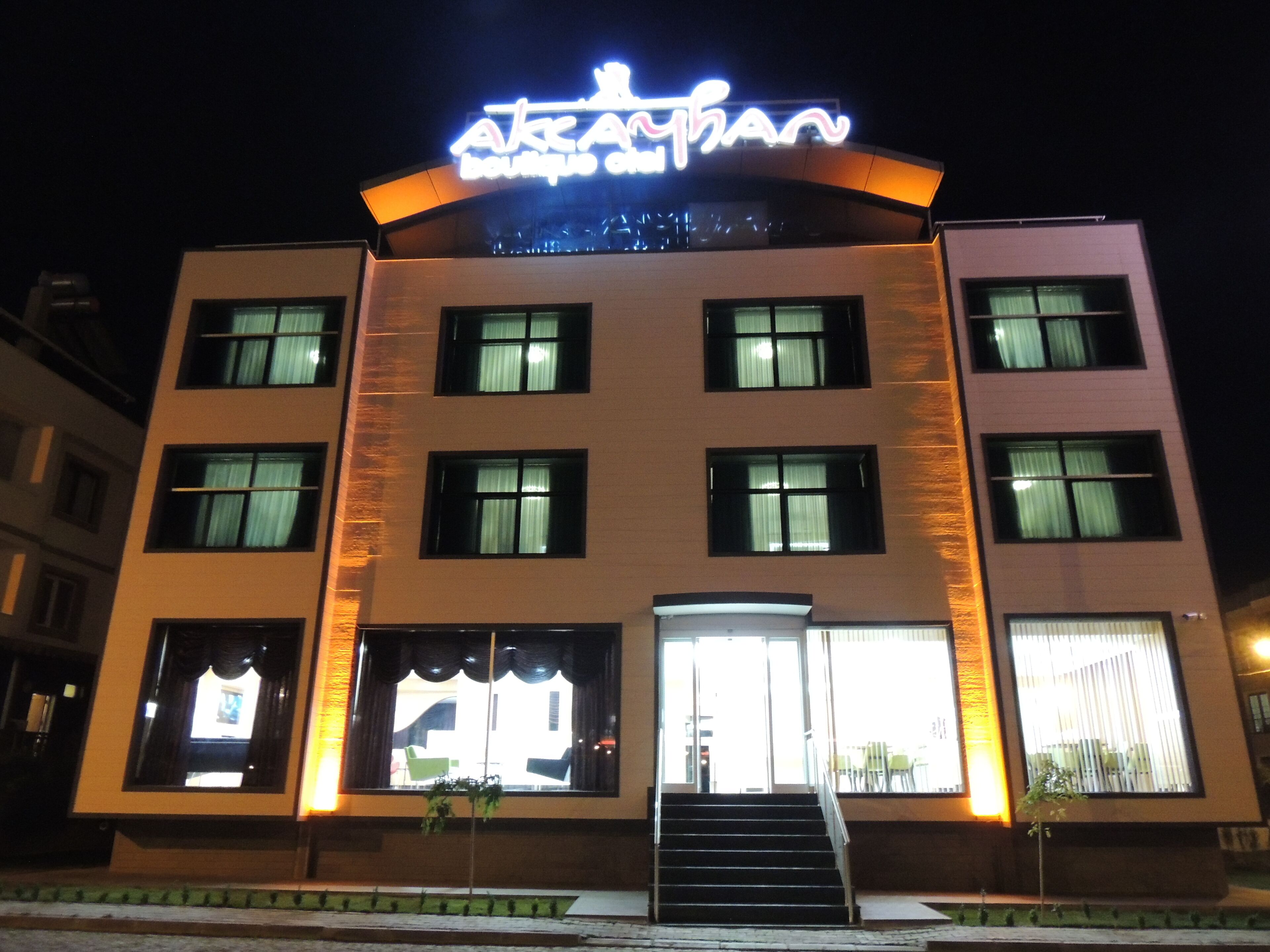 A multi-story building with a prominent illuminated sign at the top.