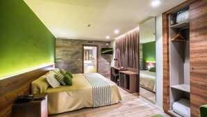 A modern bedroom with a large bed, a desk, and a walk-in closet. - Hotel Venta Baños (Murcia)