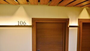 A hotel room with a wooden door, a number '106' above it, and a ceiling with wooden beams. - Hotel Venta Baños (Murcia)