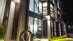 A modern multi-story building with large windows and a well-lit entrance. - Galilee (Magong)
